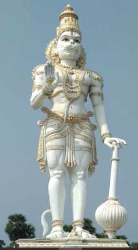 A statue of Lord Hanuman stands majestically on a pedestal, showcasing intricate details and a serene expression
