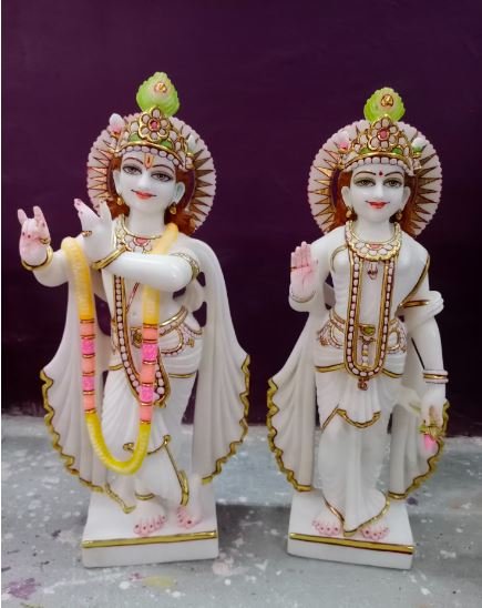 Two intricately designed figurines of Hindu deities displayed against a vibrant purple background, showcasing cultural artistry.