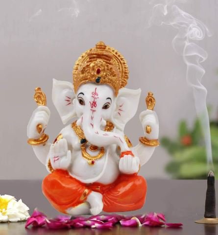 Elephant statue adorned with incense sticks and vibrant flowers, creating a serene and spiritual atmosphere.
