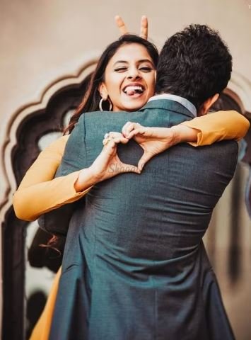 Two people hug tightly, creating a heart shape with their hands, capturing a tender expression of love and affection.